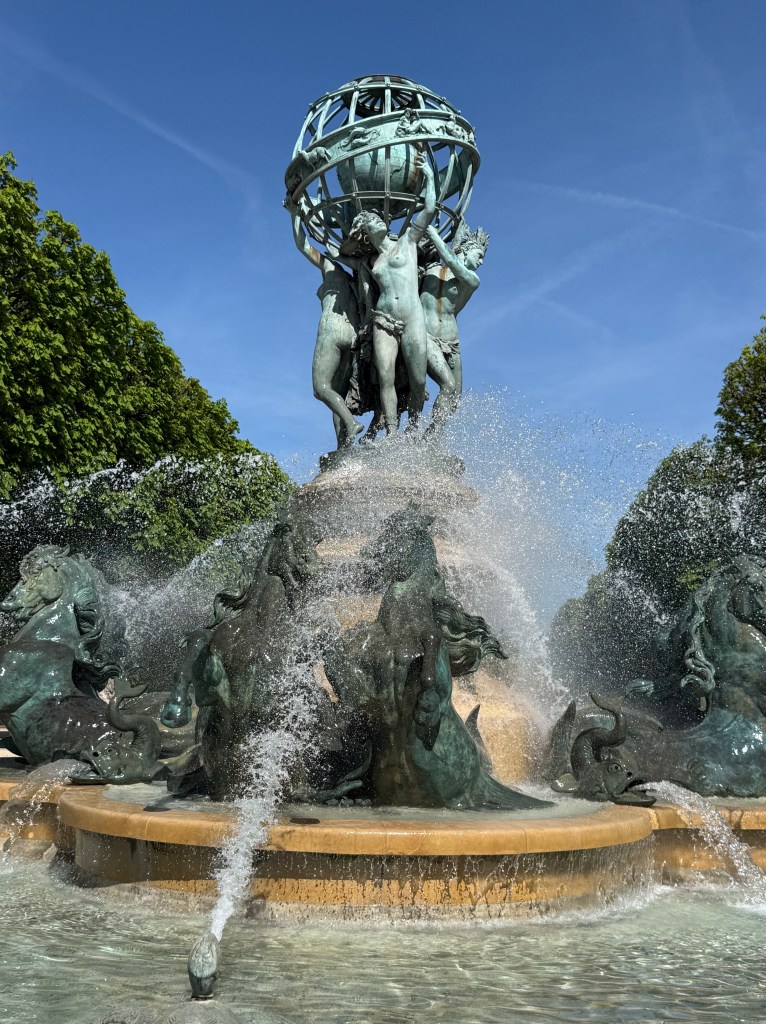 Close up of the centerpiece of the fountain featuring four female figures representing the four parts of the world: Europe, Asia, Africa and America, twisting their bodies to turn the sphere.