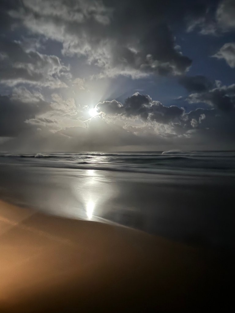 Moon shining on the water and a larger area of the beach at Cape Vidal in St Lucia