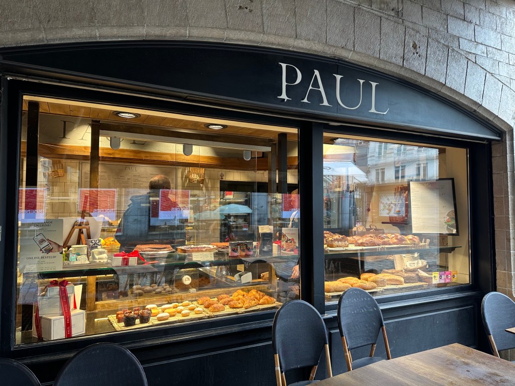 Shop window of Paul's in Brussels showing a big display of confectionary and baked goods.